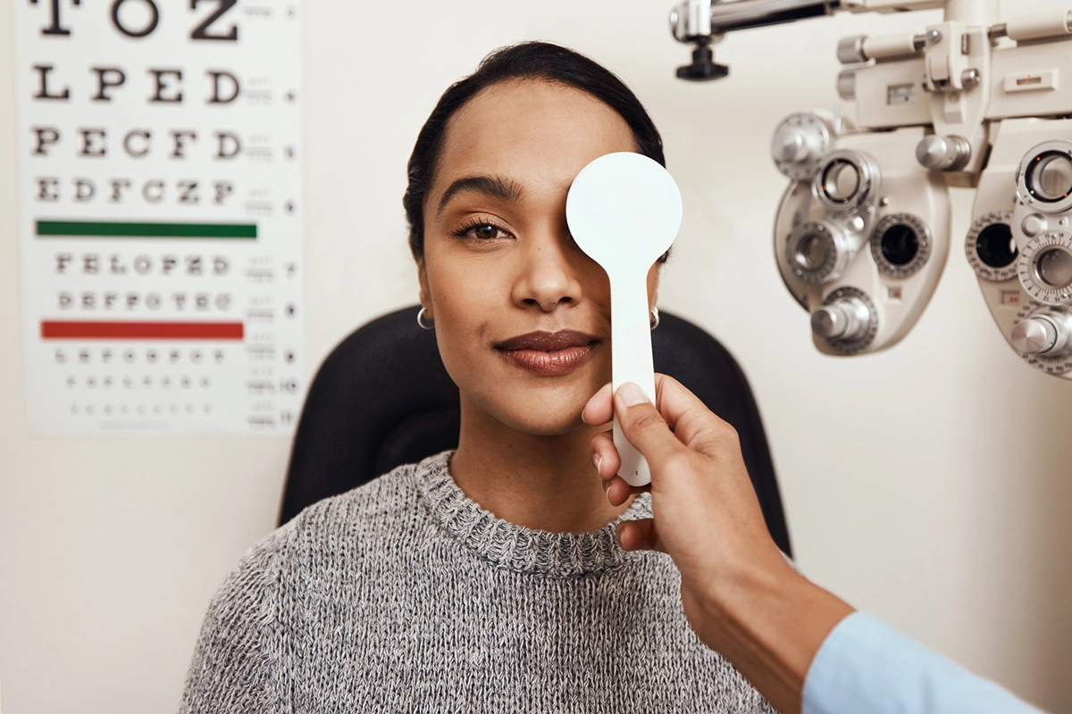 A female patient having an eye exam conducted by an Optometrist where one is being covered